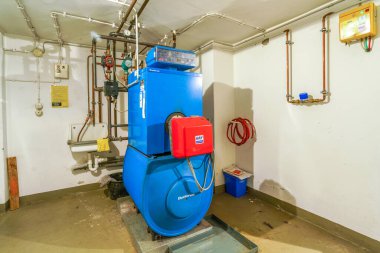 Eski mavi Buderus G 105 yağ ısıtıcısı ve 1992 'de yapılmış kırmızı Ray ocağı.