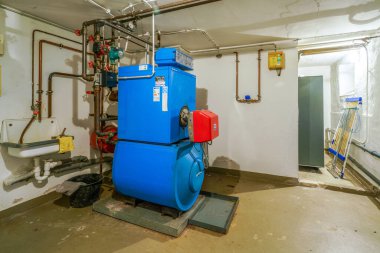 Eski mavi Buderus G 105 yağ ısıtıcısı ve 1992 'de yapılmış kırmızı Ray ocağı.