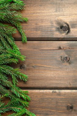 Ahşap arka planda yeşil köknar dalları. Tahtadan yapılmış tahta bir masanın üzerinde doğal ladin dalı. Yeni yıl ve Noel 'in planı. Tebrikler için hazırlık..