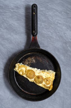 Kızarmış uskumru, soğanlı Trachurus ve kurutulmuş otlar eski bir kızartma tavasında. Taşra tarzı. Üst görünüm, gri beton arkaplan