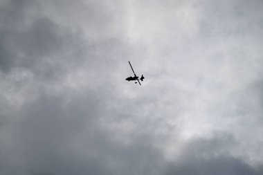 Toskana sahilinde helikopter var. Bulutlu ve mavi gökyüzü. Dibine kadar. Biri kanatları ve pervaneyi görüyor..