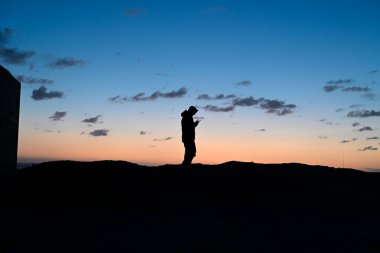 Gençler İtalyan plajında oynuyor. Bazı gençler gün batımında Viareggio plajında oynuyorlar. Bazı gençler cep telefonlarıyla oynuyorlar. Bazı gençler dans ediyor..
