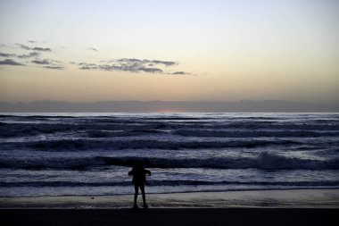 Gençler İtalyan plajında oynuyor. Bazı gençler gün batımında Viareggio plajında oynuyorlar. Bazı gençler cep telefonlarıyla oynuyorlar. Bazı gençler dans ediyor..