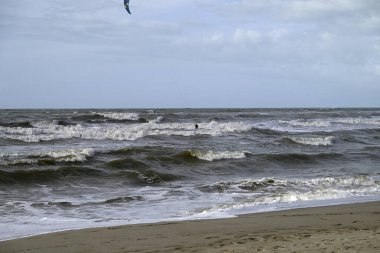 İtalya sahilinde uçurtma. Torre del Lago sahilindeki uçurtmacılar, Toskana, İtalya. Bazıları sudan çıkmakta zorlanıyor. Akdeniz.