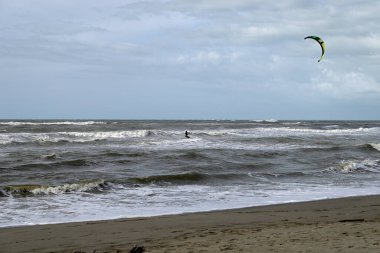 İtalya sahilinde uçurtma. Torre del Lago sahilindeki uçurtmacılar, Toskana, İtalya. Bazıları sudan çıkmakta zorlanıyor. Akdeniz.