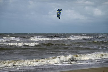 İtalya sahilinde uçurtma. Torre del Lago sahilindeki uçurtmacılar, Toskana, İtalya. Bazıları sudan çıkmakta zorlanıyor. Akdeniz.
