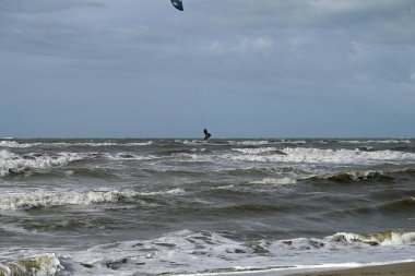 İtalya sahilinde uçurtma. Torre del Lago sahilindeki uçurtmacılar, Toskana, İtalya. Bazıları sudan çıkmakta zorlanıyor. Akdeniz.