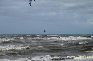 İtalya sahilinde uçurtma. Torre del Lago sahilindeki uçurtmacılar, Toskana, İtalya. Bazıları sudan çıkmakta zorlanıyor. Akdeniz.