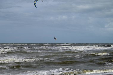 İtalya sahilinde uçurtma. Torre del Lago sahilindeki uçurtmacılar, Toskana, İtalya. Bazıları sudan çıkmakta zorlanıyor. Akdeniz.