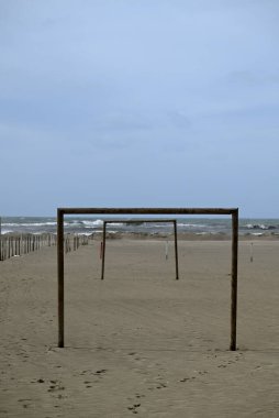 Tore del lago Puccini 'deki Akdeniz Sahili. Küçük güneşli sonbahar gökyüzü. Sudaki yansımalar.