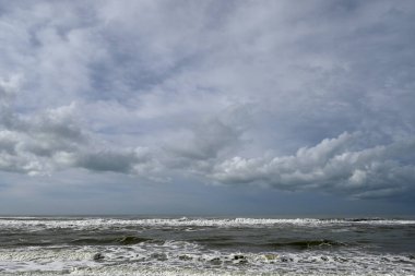 Tore del lago Puccini 'deki Akdeniz Sahili. Küçük güneşli sonbahar gökyüzü. Sudaki yansımalar.