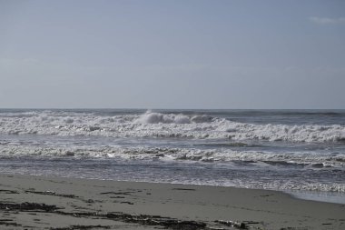 Tore del lago Puccini 'deki Akdeniz Sahili. Küçük güneşli sonbahar gökyüzü. Sudaki yansımalar.
