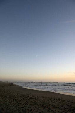 Tore del lago Puccini 'deki Akdeniz Sahili. Küçük güneşli sonbahar gökyüzü. Sudaki yansımalar.
