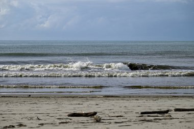 Tore del lago Puccini 'deki Akdeniz Sahili. Küçük güneşli sonbahar gökyüzü. Sudaki yansımalar.