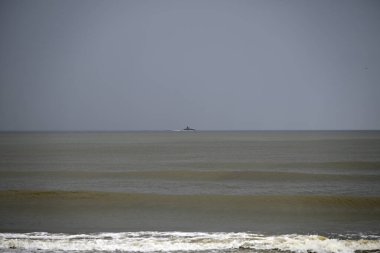 Tore del lago Puccini 'deki Akdeniz Sahili. Küçük güneşli sonbahar gökyüzü. Sudaki yansımalar.