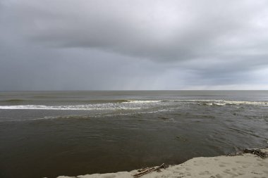 Tore del lago Puccini 'deki Akdeniz Sahili. Küçük güneşli sonbahar gökyüzü. Sudaki yansımalar.