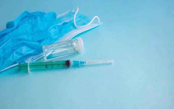 Een Spuit Handschoenen Masker Een Fles Vaccin Staan Een Blauwe — Stockfoto