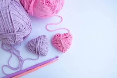 İplikler, kancalar ve iki kalp beyaz bir zeminde yatıyordu. Tatil kartı, arka plan. Sevgililer Günü konsepti, 8 Mart, Anneler Günü. Metnin için boşluk.