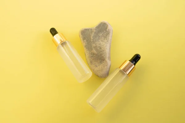 Två Flaskor Kosmetisk Flytande Transparent Gel Bredvid Grå Hjärtformad Sten — Stockfoto
