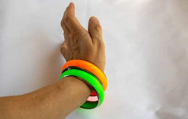 Gröna Och Orange Armband Kvinnas Hand Vit Bakgrund Silikon Mode — Stockfoto