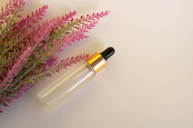 A bottle of cosmetic liquid transparent gel next to a branch of artificial lavender on a white background. Flat styling style. Place for your text.
