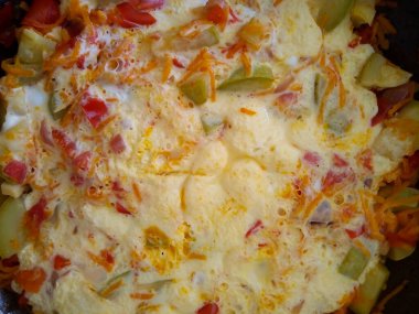 Kızartma tavasında çeşitli taze sebzelerden yapılmış sağlıklı renkli bir sebze lazanyası..