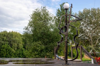 Forged monument lantern with a cello in the city square.