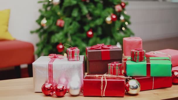 テーブルの上にクリスマスギフトボックスを閉じ 装飾品クリスマスは自宅のリビングルームで新年を祝います クリスマスお祝いのコンセプト — ストック動画