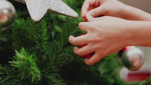 年轻的亚洲女人拿着小礼品盒装饰圣诞树 在家里的客厅里庆祝新年 圣诞庆祝概念 — 图库视频影像