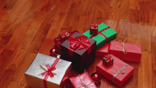 クリスマスのギフトボックスとライトの装飾品を閉じるティルトダウンカメラアングルクリスマスは自宅のリビングルームで新年を祝います クリスマスお祝いのコンセプト — ストック動画