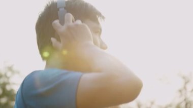 Asyalı sporcu kulaklık takıp spor yapmaya ve parkta koşmaya hazır..