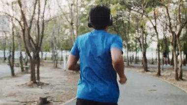 Parkta açık havada egzersiz yapan bir adam. Sağlıklı bir sporcu dışarıda koşuyor..