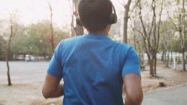 Gün batımında parkta koşan yakışıklı bir adam..