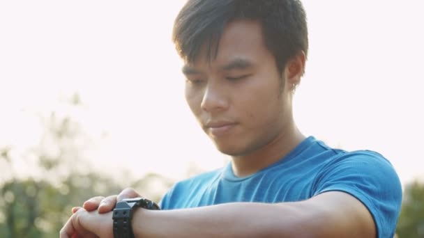 Aziatische Atleet Met Fitnesstracker Smartwatch Hardlooptraining Een Zonnige Dag Het — Stockvideo
