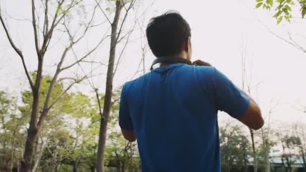 一个戴着耳机的健美男子 准备在公园里跑步和慢跑 — 图库视频影像