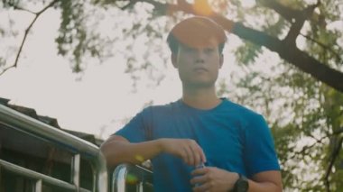 Sokaklarda koştuktan sonra su şişesinden su içen Asyalı sporcu..