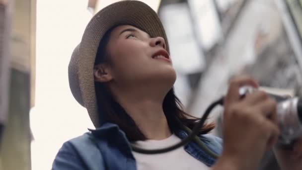 在泰国曼谷的一条小街上 年轻美丽的亚洲女旅行家头戴复古礼帽 用摄像相机拍照 享受暑假旅行的乐趣 个人旅行概念 — 图库视频影像