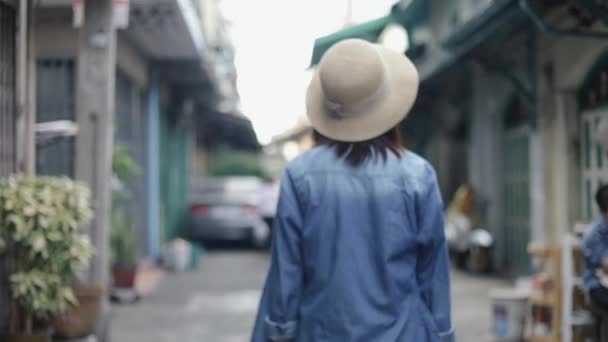 在泰国曼谷 年轻的亚洲女性旅行者头戴复古礼帽走在一条小街上的画像 暑假旅途愉快 个人旅行概念 — 图库视频影像
