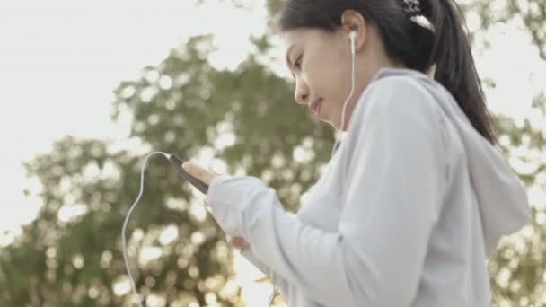 Koşucu Atlet Asyalı Kadın Akıllı Telefon Kullanıyor Müzik Dinliyor Sağlık — Stok video