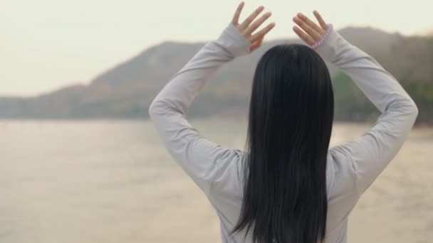 迷人的亚洲田径运动员女运动员在日出时在海滩上跑前伸展身体 健康的生活方式理念 — 图库视频影像