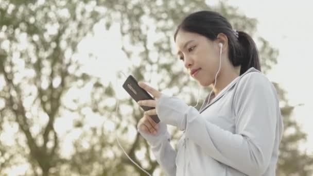 Runner Athlete Asian Woman Using Smartphone Listening Music Jogging Health — Stock Video