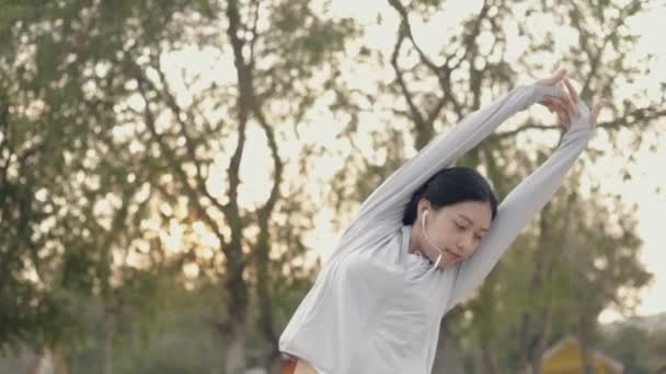 Mulher Asiática Atleta Ouvir Música Vestindo Sportswear Alongamento Com Braços — Vídeo de Stock