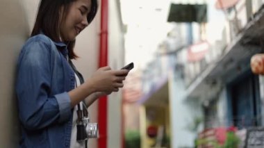 Akıllı telefon mesajı kullanan çekici Asyalı kadın, tatilde arkadaşlarıyla sosyal medya paylaşımı gezisi yapıyor..