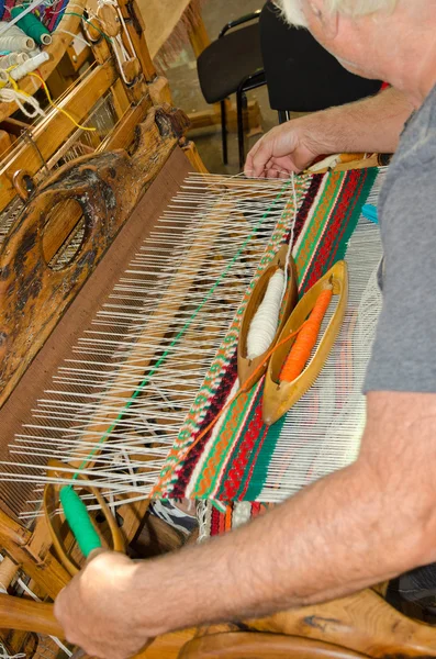 Seorang pria duduk di sebuah handloom kayu — Stok Foto