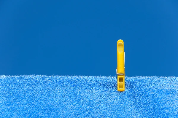 Mavi havlu üzerinde sarı clothespin