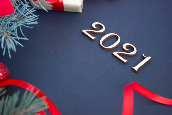 Kırmızı tonlu şık bir yeni yıl, koyu arkaplanda 2021 ahşap numara.