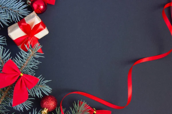Fondo de Navidad en tonos rojos y negros con juguetes y ramas de abeto, espacio para copiar — Foto de Stock