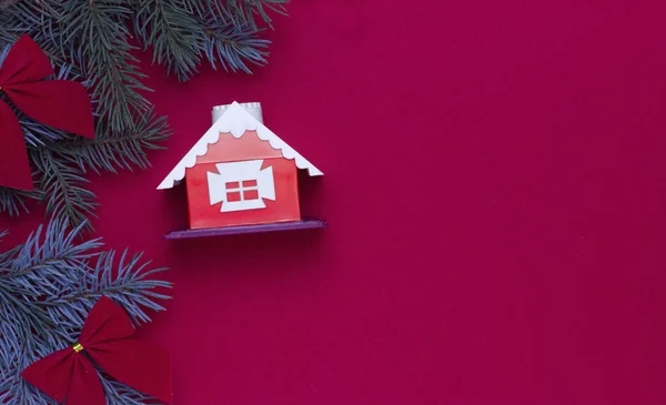 Fondo de navidad en rojo con ramas de abeto y casa de juguete, año nuevo 2021 concepto — Foto de Stock