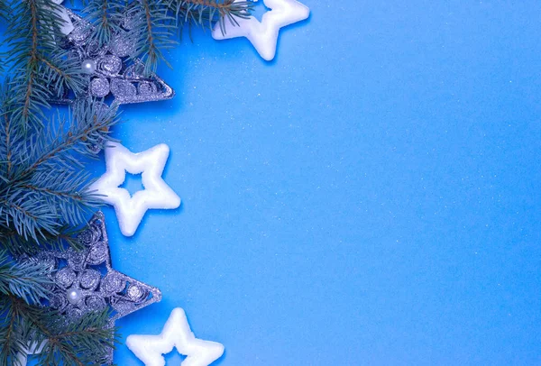 Fondo de Navidad con estrellas sobre un fondo azul con ramas de abeto, delicada tarjeta de Navidad — Foto de Stock