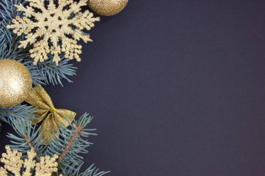 Yeni yıl kartı, yeni yıl süslemeleri altın Noel ağacı süslemeleri ve sol tarafta köknar dalları..